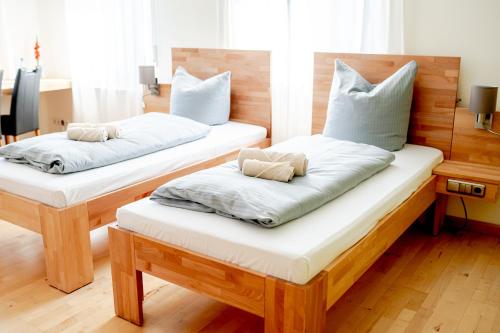 two beds with pillows on them in a room at Hotel Donau-Ries in Mertingen