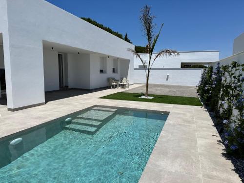 ein Swimmingpool vor einem Haus in der Unterkunft Alda & Aljosía in Chiclana de la Frontera