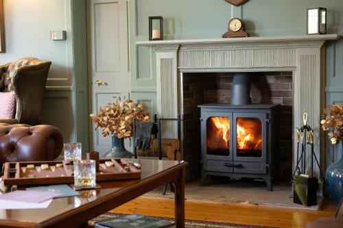 a fireplace in a living room with a stove at Knipoch House Hotel in Oban