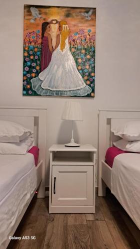 a bedroom with two beds and a painting on the wall at Istrabella Apartment in Koper