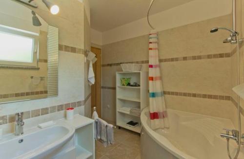 a bathroom with a tub and a sink and a shower at Apartments Jakov in Matulji