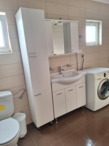 a white bathroom with a sink and a washing machine at a cozy corner in Bar