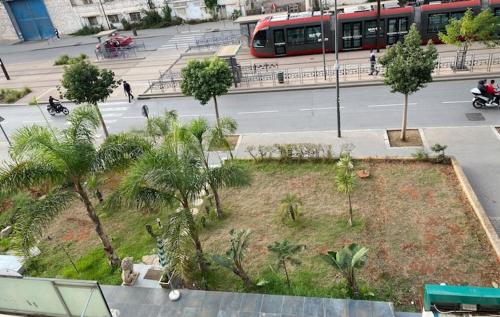 a park with palm trees and a bus on a street at Appartement Spacieux & Moderne, 2 min Gare, 10 min Plage, Parking Gratuit in Casablanca