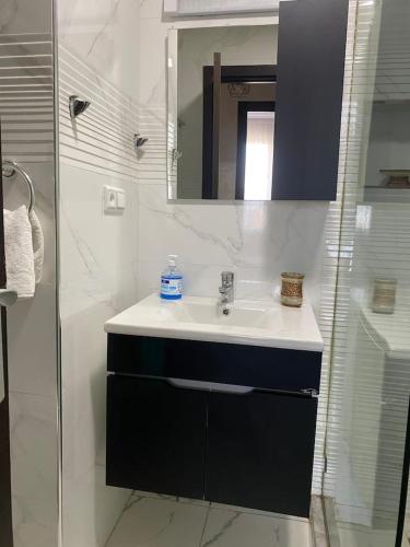a bathroom with a sink and a mirror and a shower at Appartement Spacieux & Moderne, 2 min Gare, 10 min Plage, Parking Gratuit in Casablanca