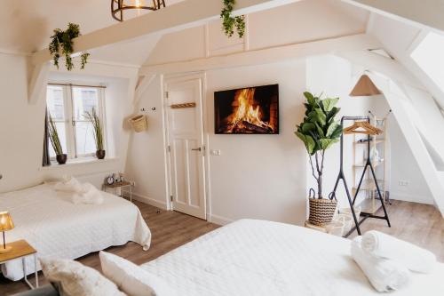 deux lits dans une chambre avec un feu sur le mur dans l'établissement The Rembrandt - Residence, à Amsterdam