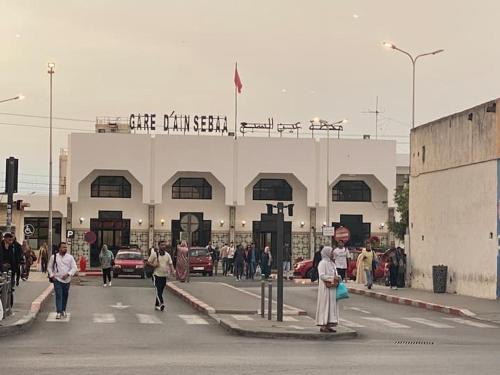 a group of people crossing a street in front of a building at Appartement Spacieux & Moderne, 2 min Gare, 10 min Plage, Parking Gratuit in Casablanca