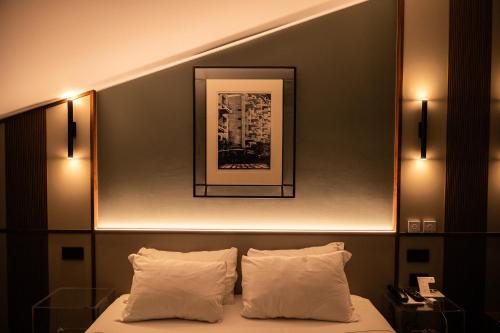 a hotel room with a bed with two pillows at Hotel Duomo Cremona in Cremona