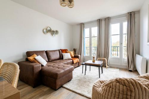 una sala de estar con un sofá y una mesa en Le Mana, 7 pers 2 chambres 12min Disneyland Paris, en Bailly-Romainvilliers