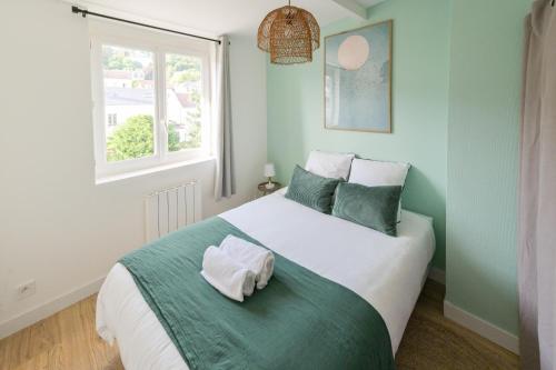 - une chambre dotée d'un grand lit avec des oreillers verts et blancs dans l'établissement Washington 3, au Havre