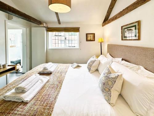 a bedroom with a large white bed with pillows at Spike by The Suffolk Cottage Collection in Chillesford
