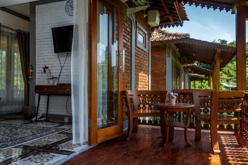 a patio with a table and chairs on a porch at Balkondes Majaksingi in Borobudur