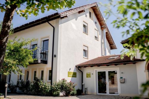 a white house with a balcony and a door at Hotel Donau-Ries in Mertingen