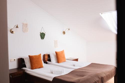 a bedroom with two beds with orange pillows at ZimaSnow Ski & Spa Club in Bukovel