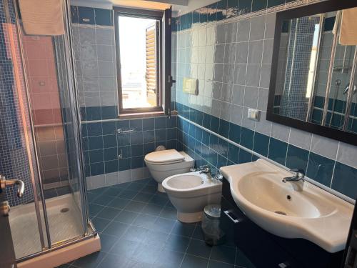 a bathroom with a toilet and a sink and a shower at Syfar Palace Hotel in Acquedolci