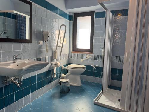 a blue tiled bathroom with a toilet and a sink at Syfar Palace Hotel in Acquedolci