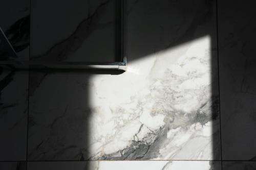 a shadow of a window on a marble floor at Hotel Palas Grand View in Iaşi