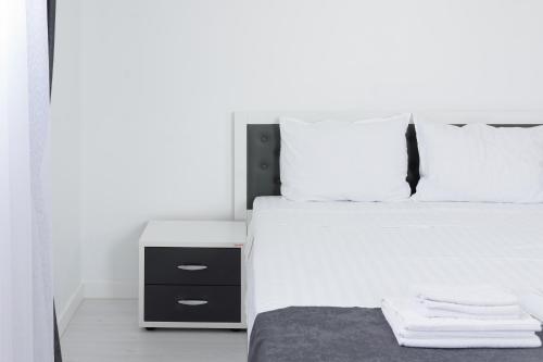 a bedroom with a large white bed and a night stand at Hotel Palas Grand View in Iaşi