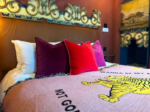 a bedroom with a bed with colorful pillows at The Bell in Ticehurst in Ticehurst