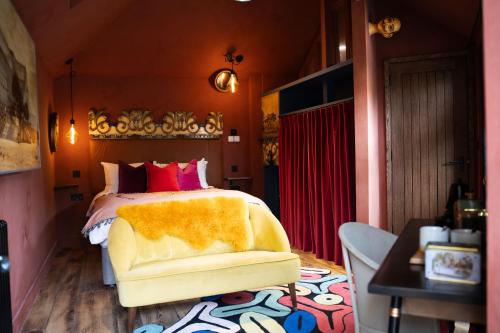 a bedroom with a bed and a chair in a room at The Bell in Ticehurst in Ticehurst