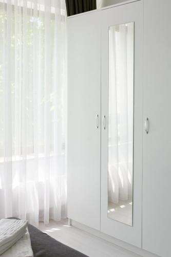 a white wardrobe with a mirror in a bedroom at Hotel Palas Grand View in Iaşi