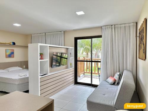 a bedroom with a bed and a couch and a window at Resort VG SUN por Be My Guest! in Caucaia