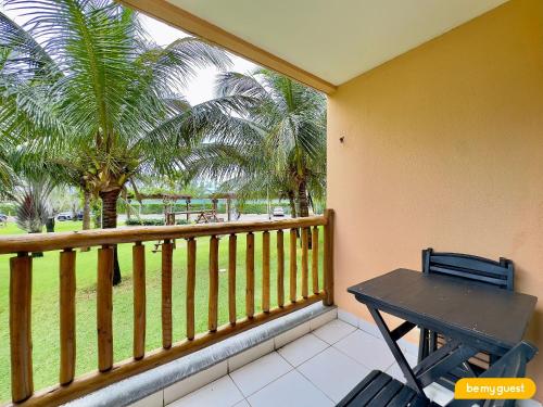 a balcony with a wooden railing with a table and palm trees at Resort VG SUN por Be My Guest! in Caucaia