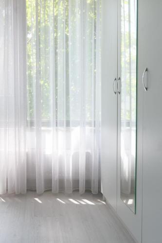 a room with a window with white curtains at Hotel Palas Grand View in Iaşi