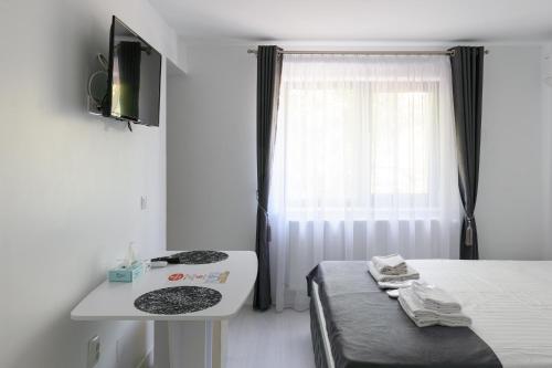 a bedroom with a bed and a table and a window at Hotel Palas Grand View in Iaşi
