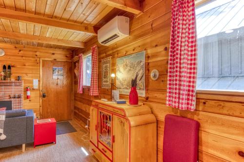 a living room with wooden walls and red chairs at Sno-bird #8 in Government Camp
