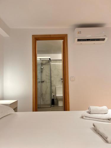 a bedroom with a white bed and a shower at Quince city center 3 in Heraklio