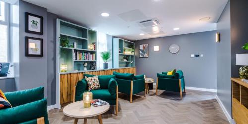 a waiting room with green chairs and a table at City Studios, Preston in Preston