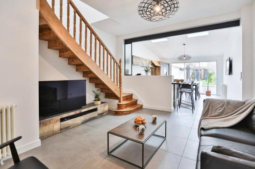 un salon avec un canapé et une télévision dans l'établissement Maison proche plage présidents, à Les Sables-dʼOlonne