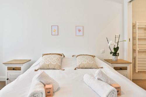 une chambre avec un grand lit blanc avec deux tables dans l'établissement Maison proche plage présidents, à Les Sables-dʼOlonne