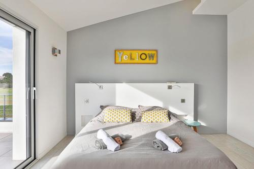 - une chambre dotée d'un lit avec une horloge murale dans l'établissement Villa du golf - proche plage, à Talmont-Saint-Hilaire