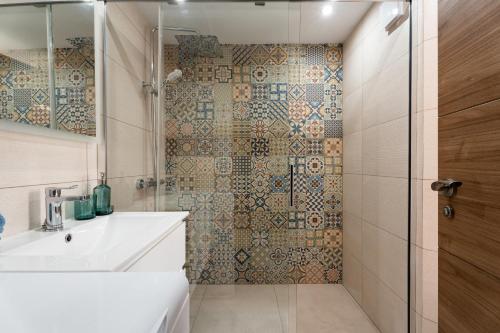a bathroom with a shower and a white sink at The Skippers Nest in San Miguel de Abona