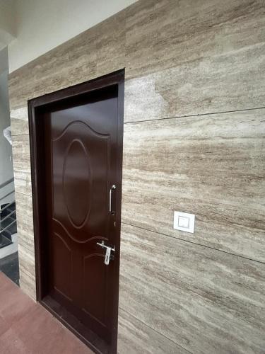 a wooden door in a room with a wooden wall at OG Home Stays in Bengaluru