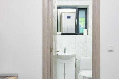 a bathroom with a toilet and a sink and a mirror at Hotel Palas Grand View in Iaşi