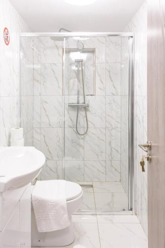 a white bathroom with a shower and a toilet at Hotel Palas Grand View in Iaşi