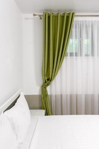a bedroom with a bed with a green curtain at Hotel Palas Grand View in Iaşi