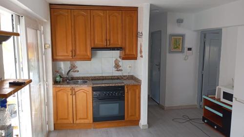 una cucina con mobili in legno e una stufa di Casa Víctor a Ciudad-Rodrigo