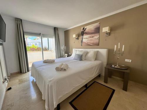 a bedroom with a large white bed and a window at VIP Dominion Beach Estepona in Estepona