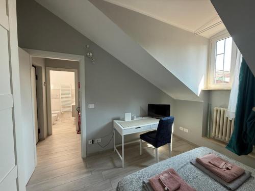 a bedroom with a desk and a bed with a chair at Splendida mansarda nel cuore della città in Turin