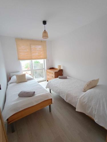 two beds in a bedroom with a window at Apartament Mazury in Ryn