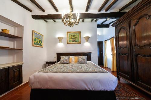 a bedroom with a bed and a chandelier at Le Hameau in Saint-Paul-de-Vence