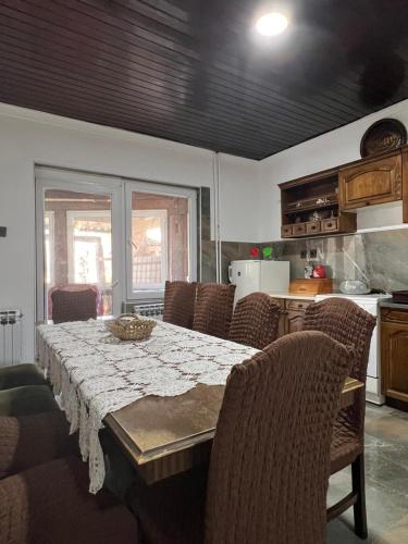 a dining room with a table and chairs and a kitchen at Top House in Šabac
