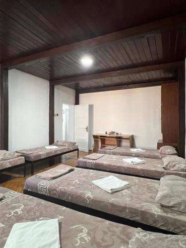 a room with three beds and a table at Top House in Šabac