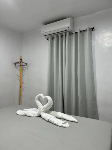 two towels in the shape of a heart sitting on a bed at KADIJ Guest House in San Juan