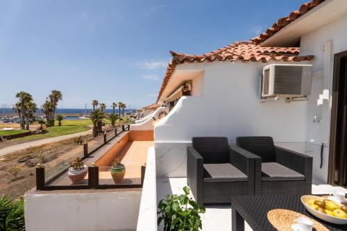 a balcony with two chairs and a table on a house at The Skippers Nest in San Miguel de Abona