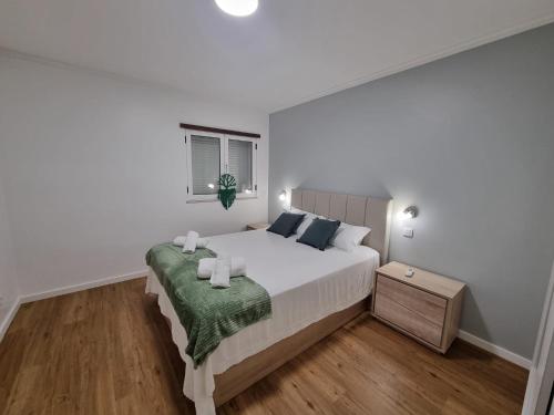 a white bedroom with a bed with a green blanket at Julianas Place by Susys Holidays in Funchal
