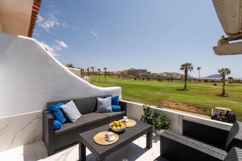 a patio with a couch and tables on a balcony at The Skippers Nest in San Miguel de Abona